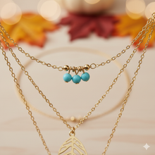 Laden Sie das Bild in den Galerie-Viewer, DIXIE | Goldfarbene Halskette mit Feder und Blatt Anhängern und süßen kleinen türkise Perlen