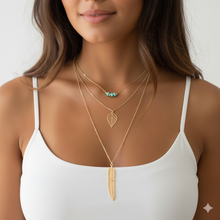 Laden Sie das Bild in den Galerie-Viewer, DIXIE | Goldfarbene Halskette mit Feder und Blatt Anhängern und süßen kleinen türkise Perlen
