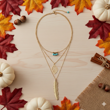 Laden Sie das Bild in den Galerie-Viewer, DIXIE | Goldfarbene Halskette mit Feder und Blatt Anhängern und süßen kleinen türkise Perlen
