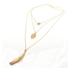 Load image into Gallery viewer, DIXIE | Goldfarbene Halskette mit Feder und Blatt Anhängern und süßen kleinen türkise Perlen
