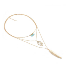 Laden Sie das Bild in den Galerie-Viewer, DIXIE | Goldfarbene Halskette mit Feder und Blatt Anhängern und süßen kleinen türkise Perlen
