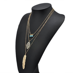 DIXIE | Goldfarbene Halskette mit Feder und Blatt Anhängern und süßen kleinen türkise Perlen