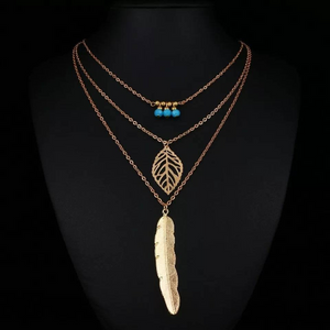 DIXIE | Goldfarbene Halskette mit Feder und Blatt Anhängern und süßen kleinen türkise Perlen