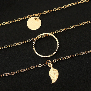 ARIANA | Mehrlagige goldene Halskette mit Blättern Münze und kleinen lila Kristall