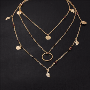 ARIANA | Mehrlagige goldene Halskette mit Blättern Münze und kleinen lila Kristall